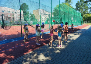 Boisko szkolne. Uczniowie grają w piłkę.