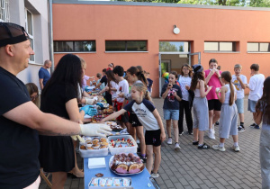 Impreza środowiskowa z okazji Dnia Dziecka 2026 na boisku szkolnym z udziałem uczniów, nauczycieli i rodziców.
