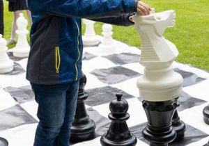 Uczniowie grający w szachy w ogrodach Pałacu Herbsta