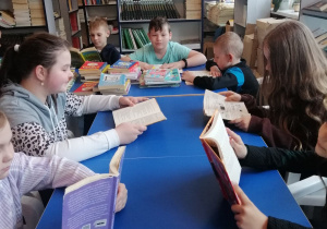 Uczniowie czytają książki na przerwie w bibliotece szkolnej.