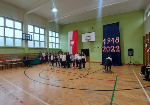 Uczniowie w sali gimnastycznej podczas uroczystego apelu z okazji 11 listopada