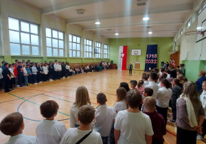 Uczniowie w sali gimnastycznej podczas uroczystego apelu z okazji 11 listopada