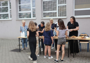 Uczniowie i nauczyciele podczas zabaw i gier rekreacyjnych na boisku szkolnym zorganizowanych z okazji Dnia Dziecka