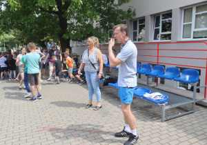 Uczniowie i nauczyciele podczas zabaw i gier rekreacyjnych na boisku szkolnym zorganizowanych z okazji Dnia Dziecka