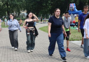 Uczniowie i nauczyciele podczas zabaw i gier rekreacyjnych na boisku szkolnym zorganizowanych z okazji Dnia Dziecka