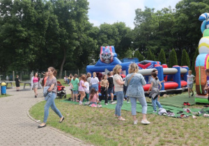 Uczniowie i nauczyciele podczas zabaw i gier rekreacyjnych na boisku szkolnym zorganizowanych z okazji Dnia Dziecka