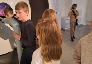Chłopiec robi zdjęcia uczniom, podczas zwiedzania muzeum